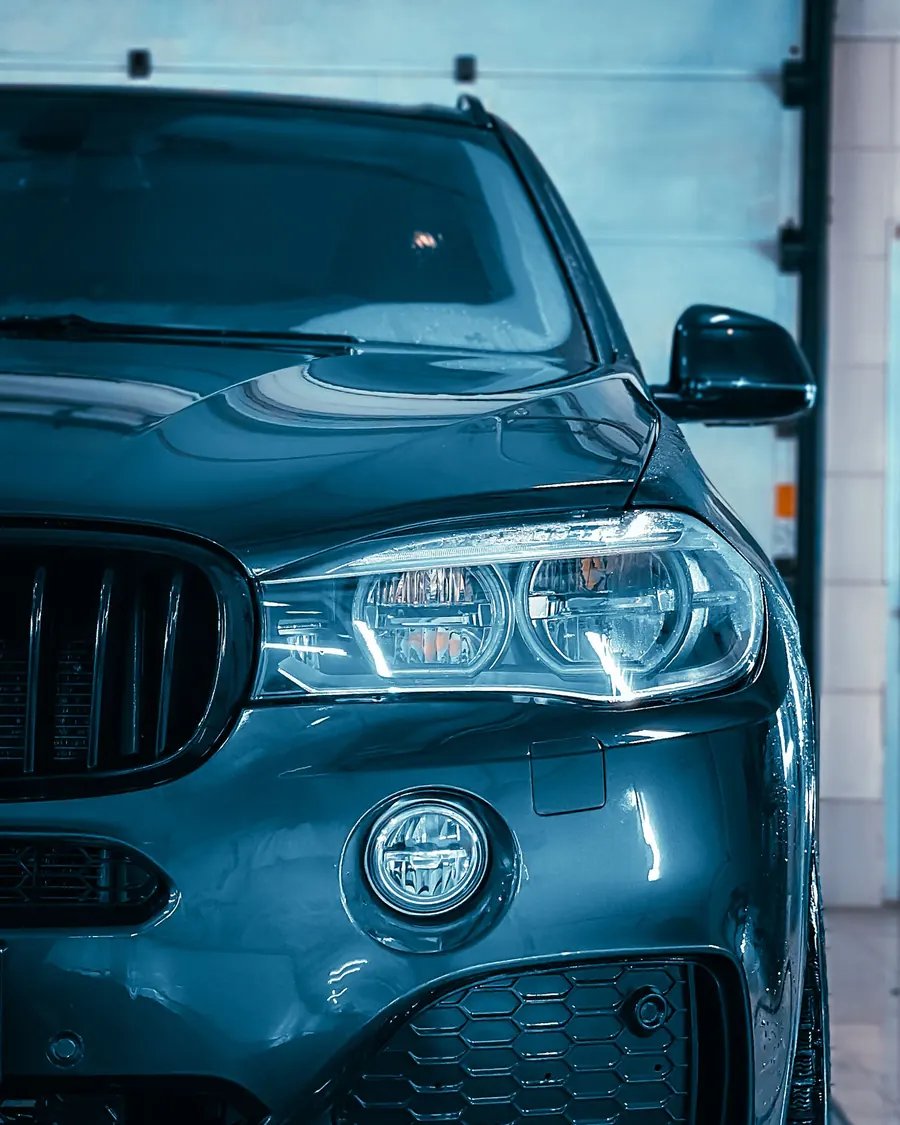 Frisch gewaschener grauer BMW X5 vor dem geöffneten Hallentor