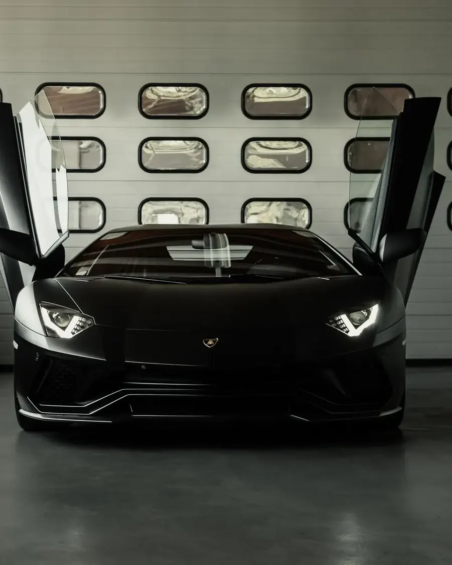 Schwarzer Lamborghini Aventador mit geöffneten Scherentüren in der Halle